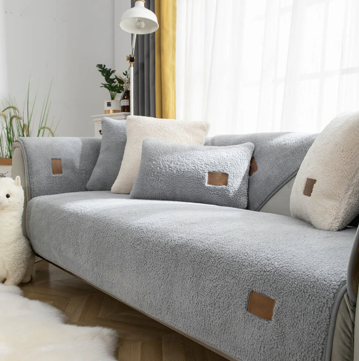 Grey sherpa-style sofa cover fitted to a two-seater sofa