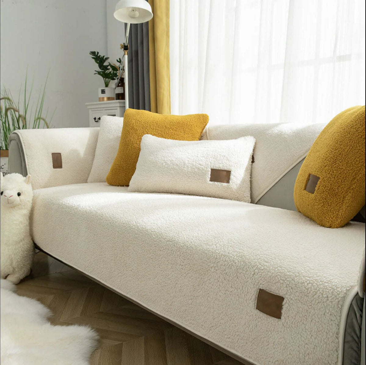 White sherpa-style sofa cover with yellow and white cushions